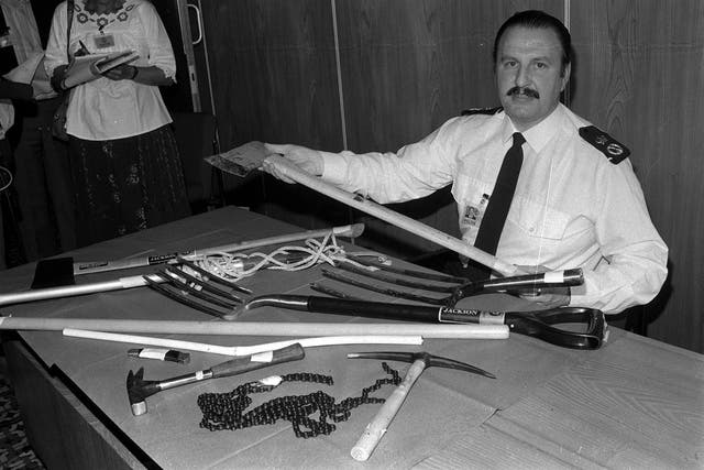 Then chief constable of the Greater Manchester Police, James Anderton, displaying some of the items that were looted and used by rioters as weapons during the riots in the Moss Side District of Manchester (Archive/PA)