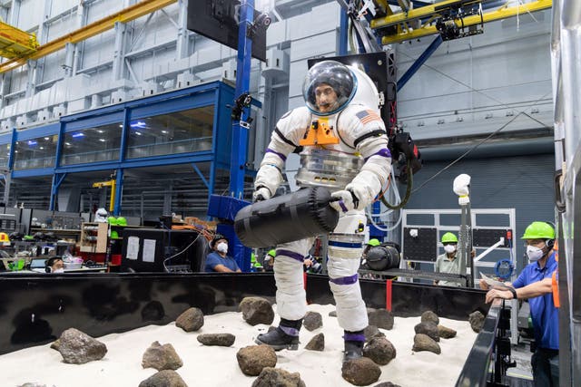 Un voluntario en un traje espacial intenta una tarea de excusión marciana simulada diseñada para probar las habilidades de los astronautas antes y después de largas temporadas a bordo de la Estación Espacial Internacional.
