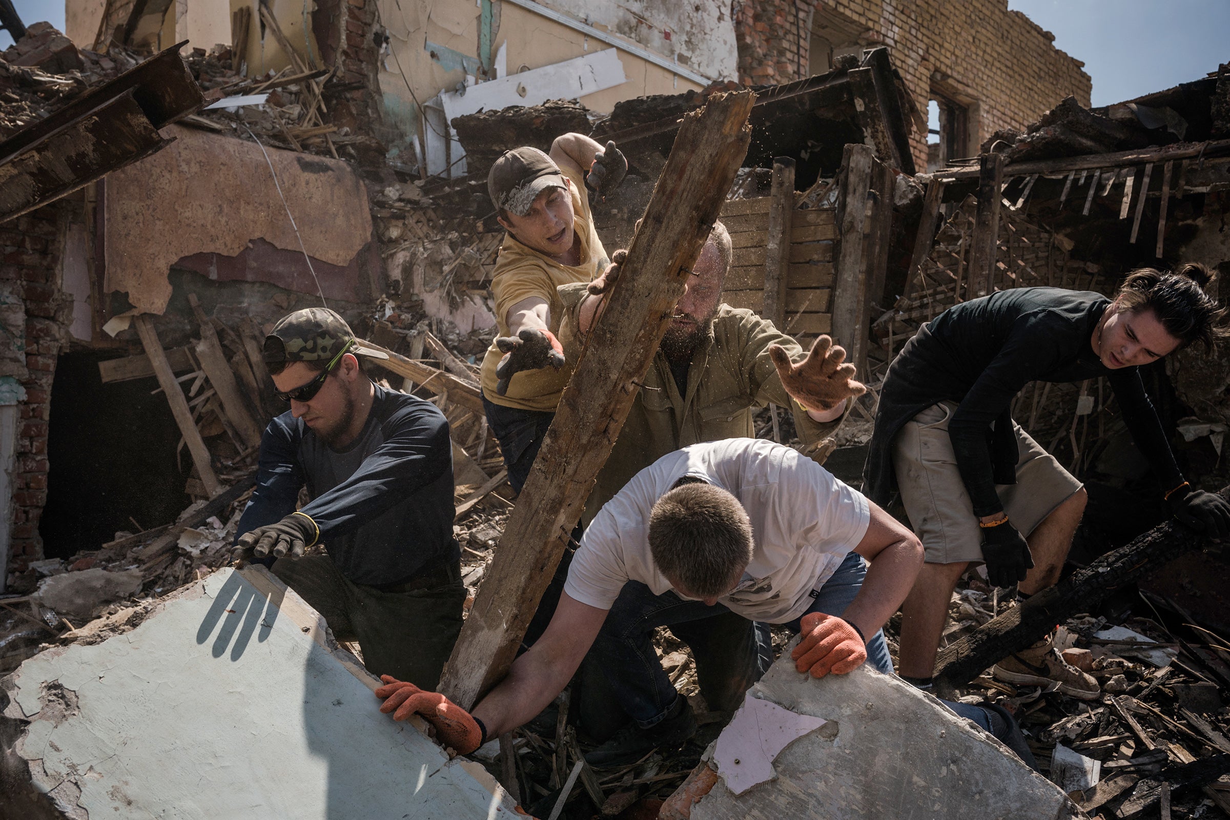 Volunteers clear an area of Kharkiv hit by a missile