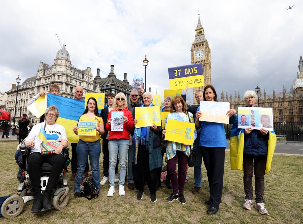 Protesters holding Ukrainian flags and banners as they attend a Vigil for Visas protest outside the Houses of Parliament, central London (James Manning/PA)