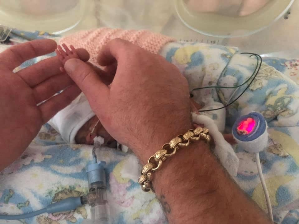Dad Rob Hampson holding baby Elsie's tiny hand