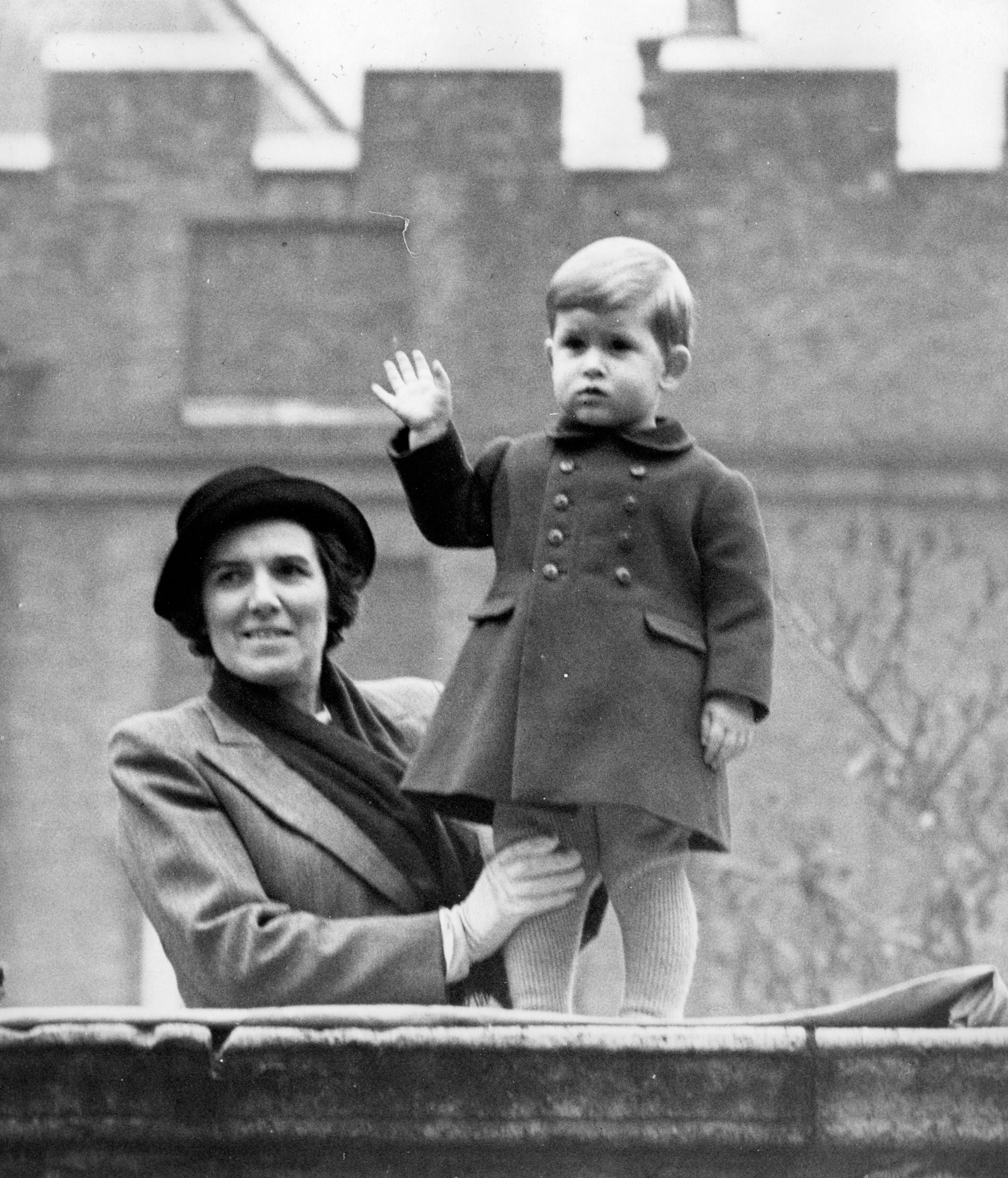 Prince Charles waves to the crowd from the wall of Clarence House before the State Opening of Parliament in 1952 (PA)