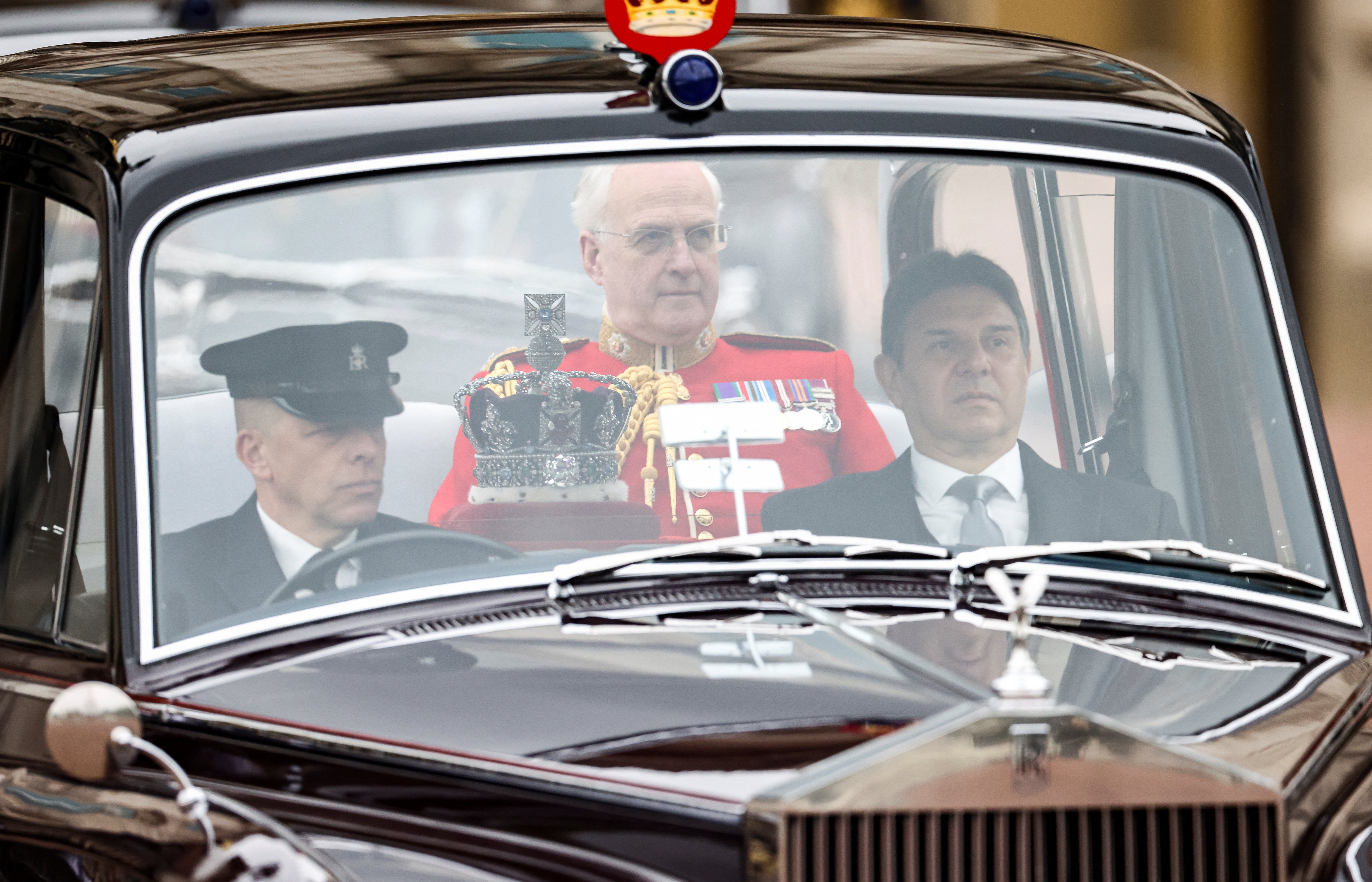 A car carrying Britain's Queen Elizabeth's crown rides by the Buckingham Palace