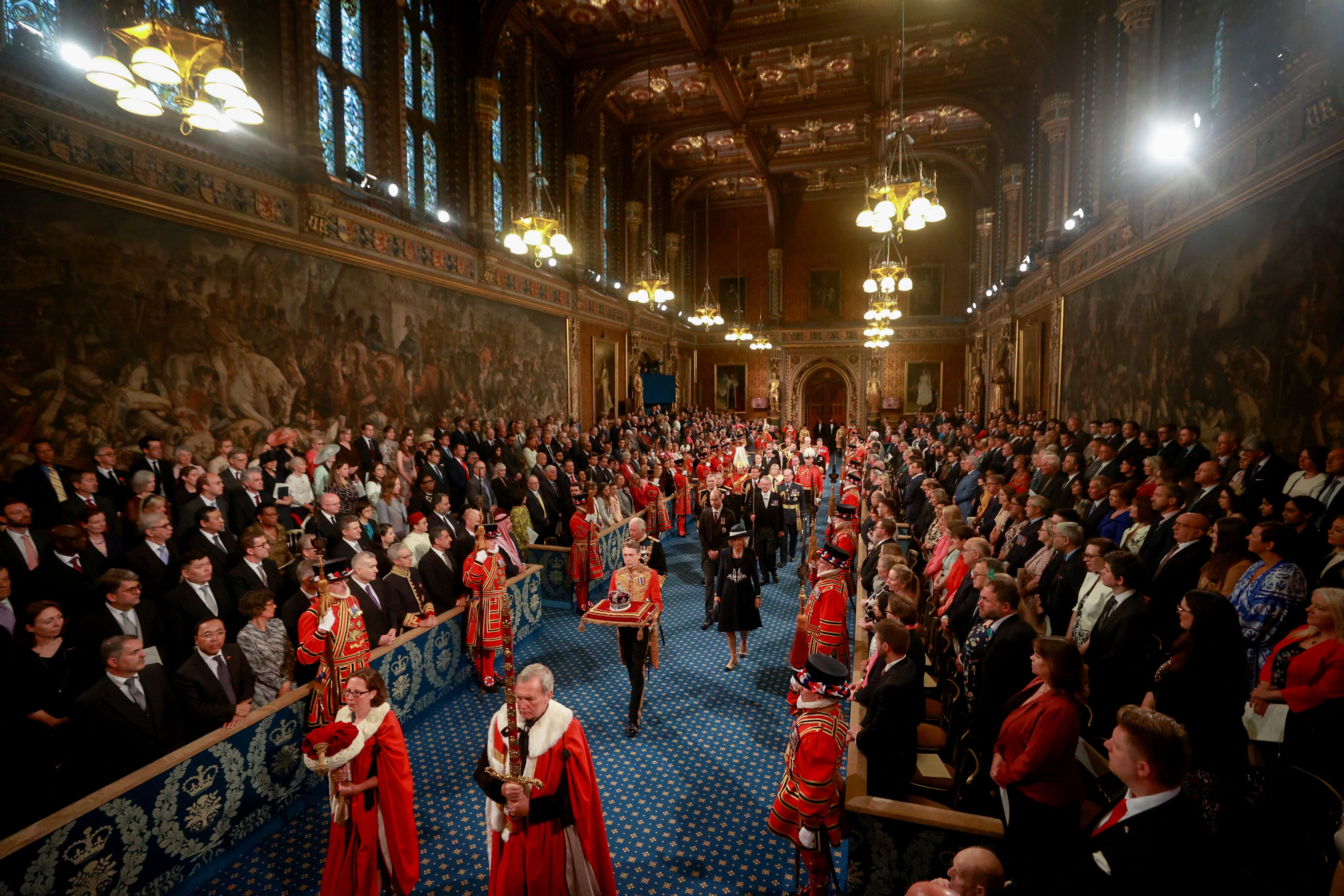 The Prince of Wales and the Duchess of Cornwall with the Duke of Cambridge proceed behind the Imperial State Crown through the Royal Gallery during the state opening of parliament in the House of Lords