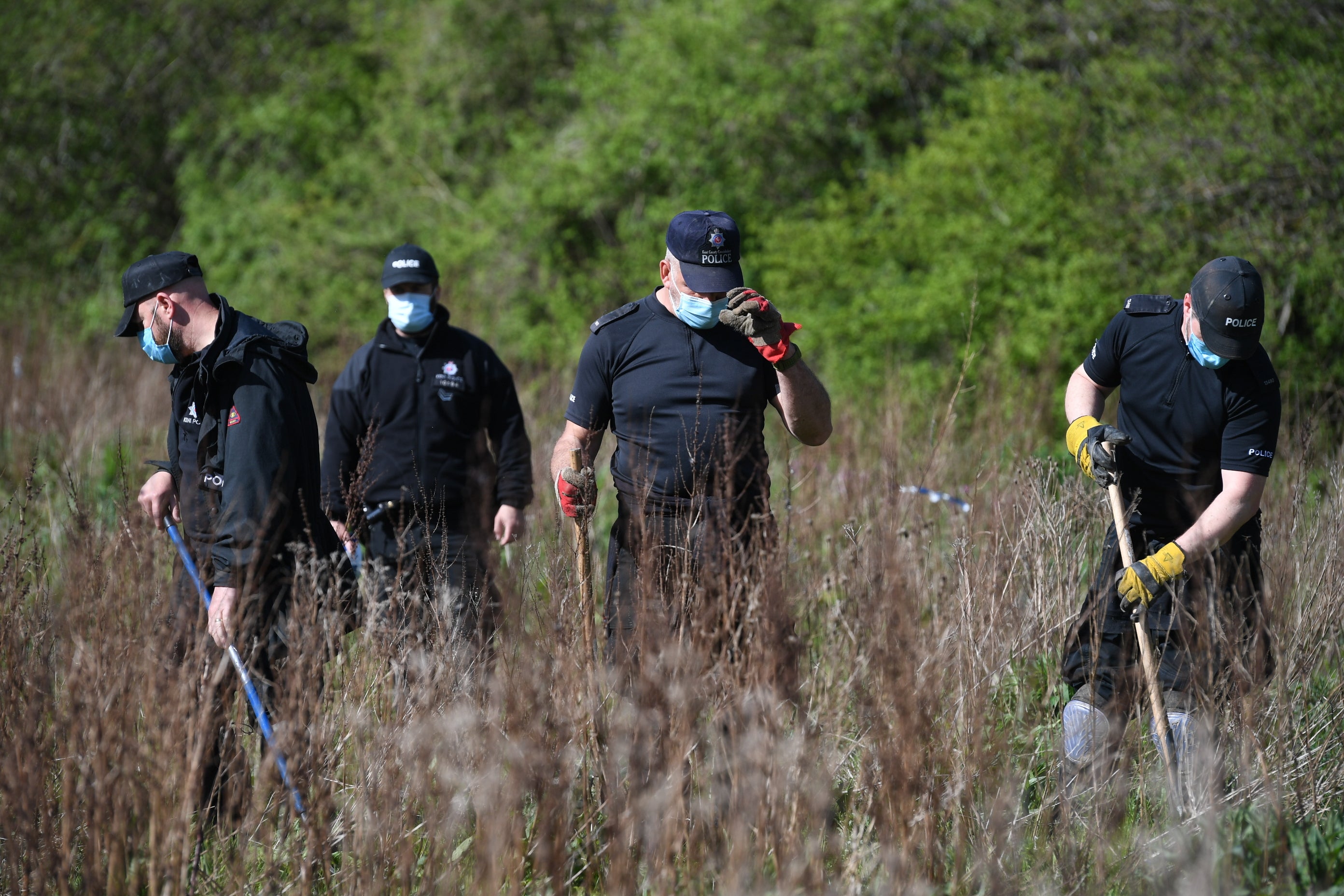 Police officers searching grassland near an address in Sunshine Corner Avenue, Aylesham, Kent in connection with the death of PCSO Julia James