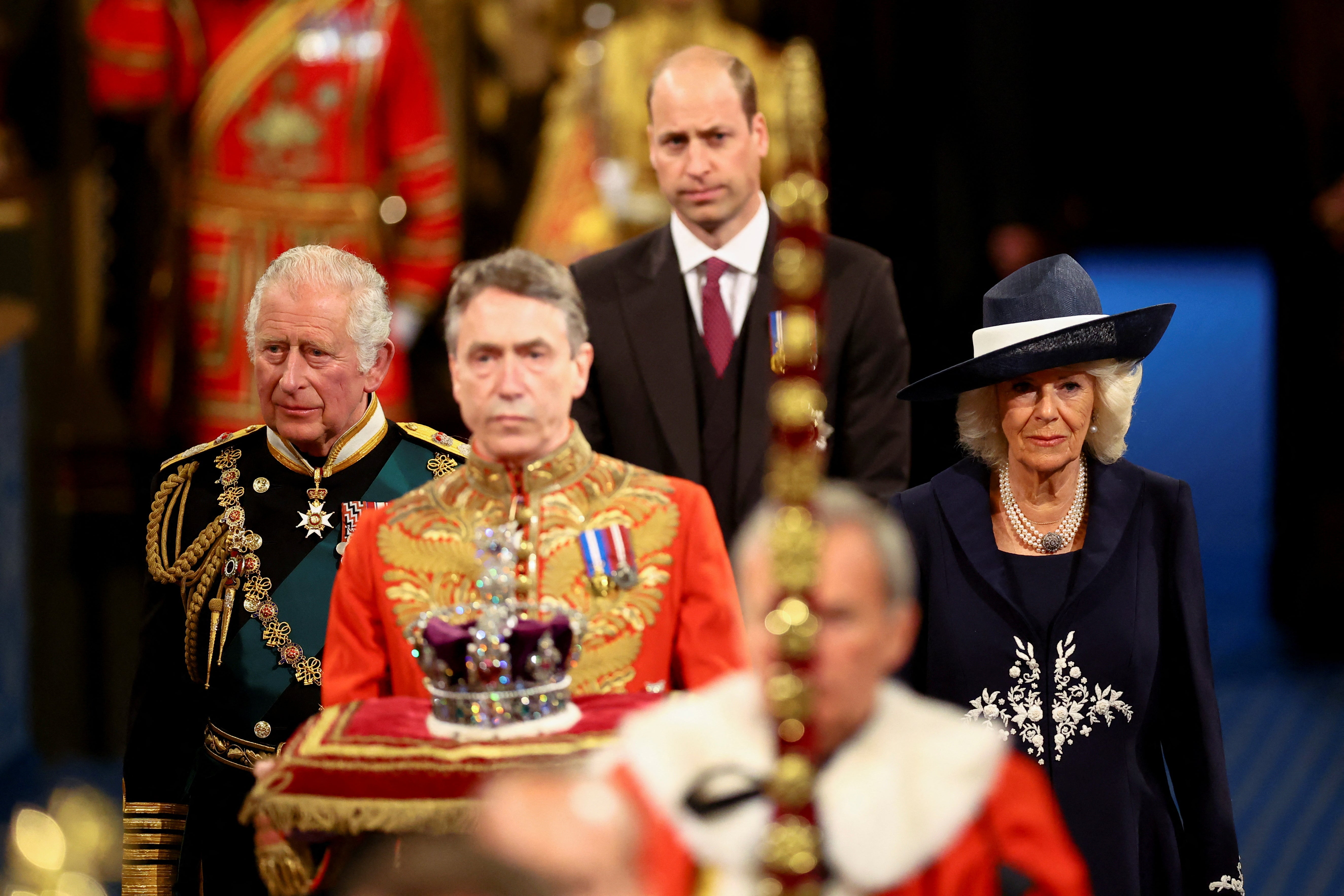 The Prince of Wales and the Duchess of Cornwall, with the Duke of Cambridge, back centre, proceed behind the Imperial State Crown through the Royal Gallery during the State Opening of Parliament (Hannah McKay/PA)