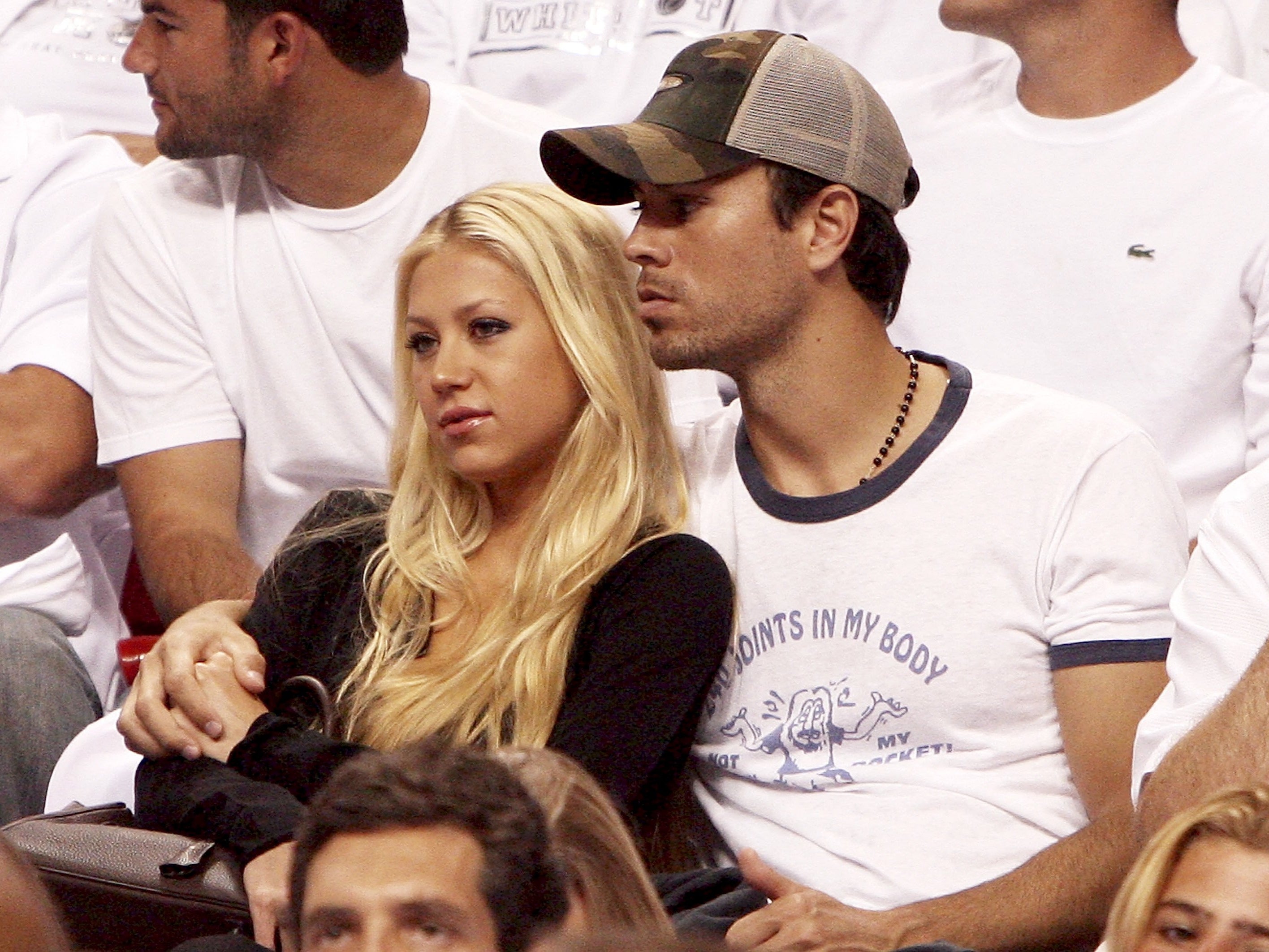 Anna Kournikova and singer Enrique Iglesias hold each other as they watch the the New Jersey Nets take on the Miami Heat in game one of the Eastern Conference semifinals at American Airlines Arena on May 8, 2006
