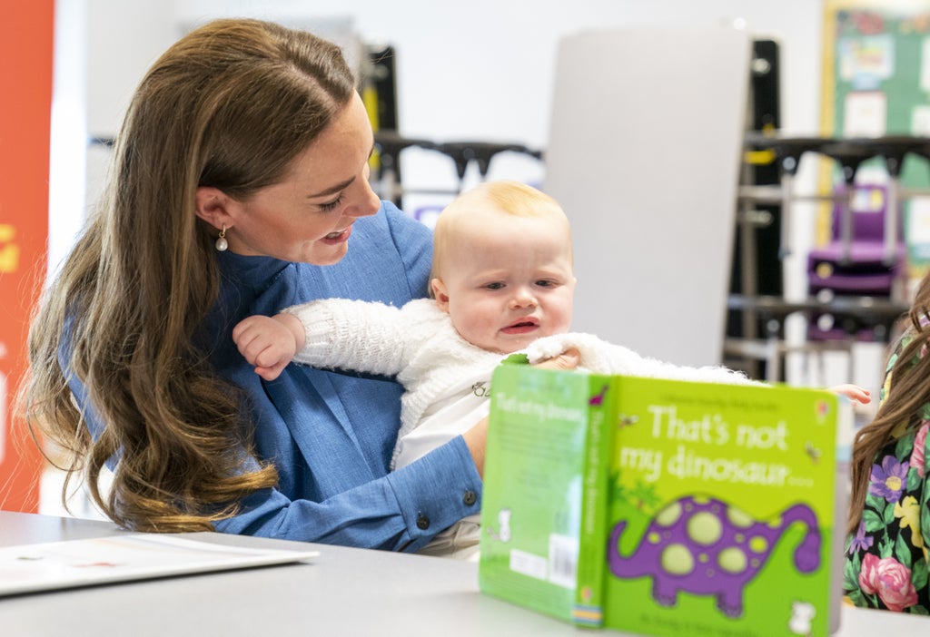 Kate cuddles baby as she learns about innovative education project