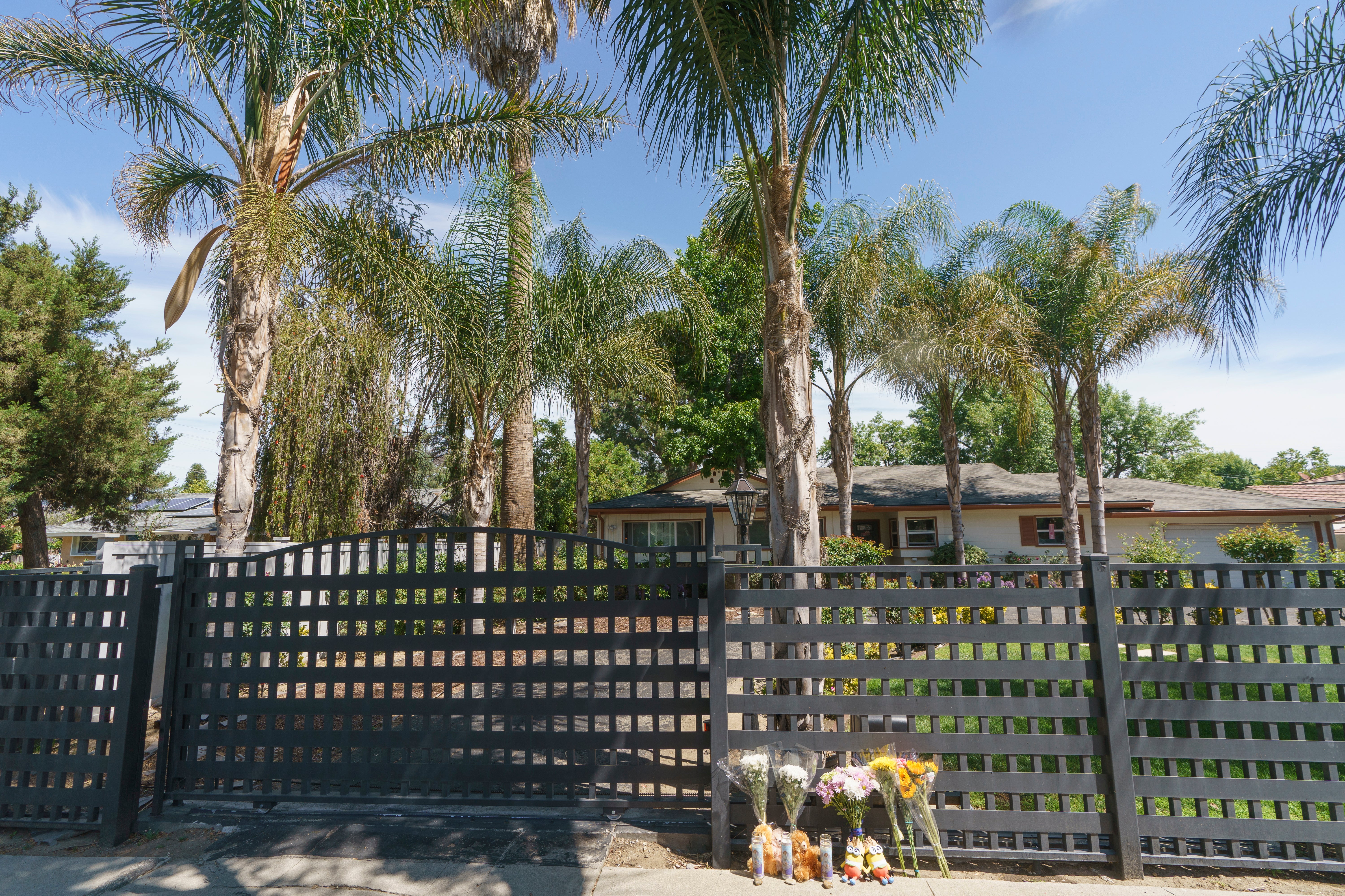 Flowers and teddy bears are left outside a ranch-style house in the West Hills neighborhood of the San Fernando Valley in Los Angeles, Monday, May 9, 2022.