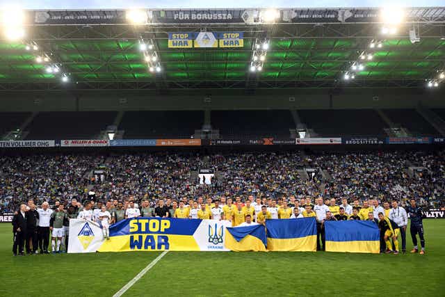 Ukraine and Borussia Monchengladbach players hold up a banner to show solidarity against Russia’s invasion of Ukraine (Federico Gambarini/AP/PA)