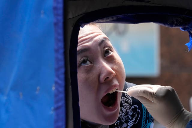 <p>A resident opens her mouth to be swabbed during a mass Covid test on Thursday</p>