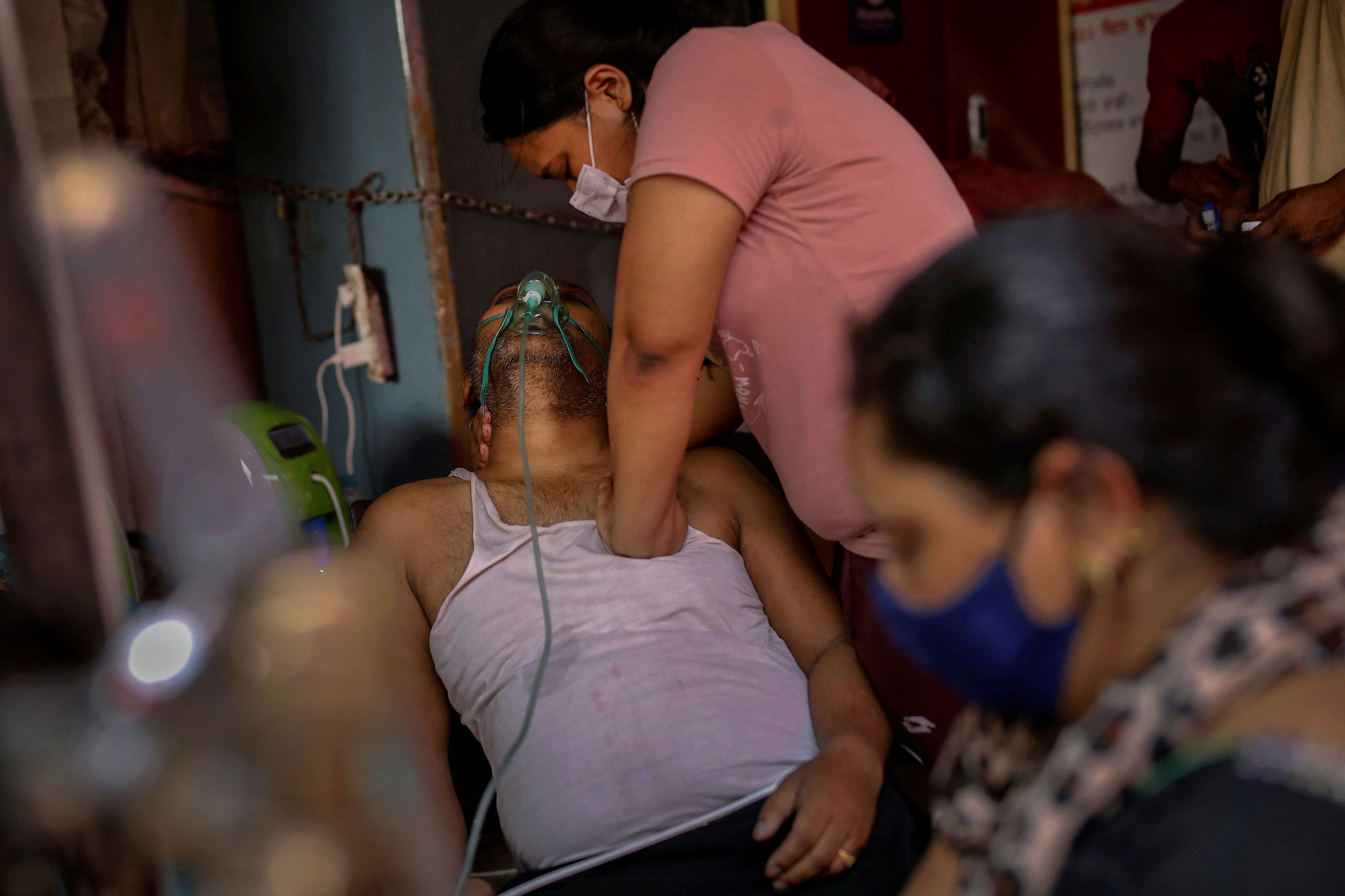 Manisha Bashu presses the chest of her father, who was having difficulty breathing, after he fell unconscious while receiving oxygen support at a Gurdwara (Sikh temple) in Ghaziabad on 30 April 2021