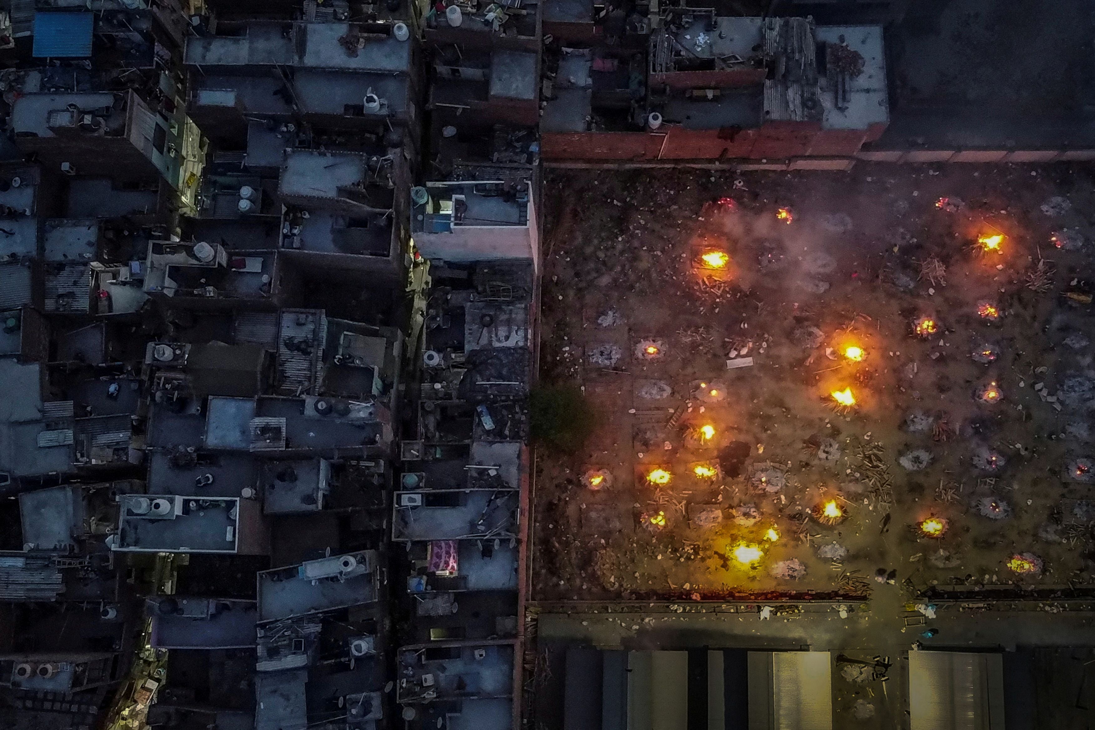 Residences surround the grounds of a crematorium during a mass cremation for victims of Covid-19 in New Delhi on 22 April 2021