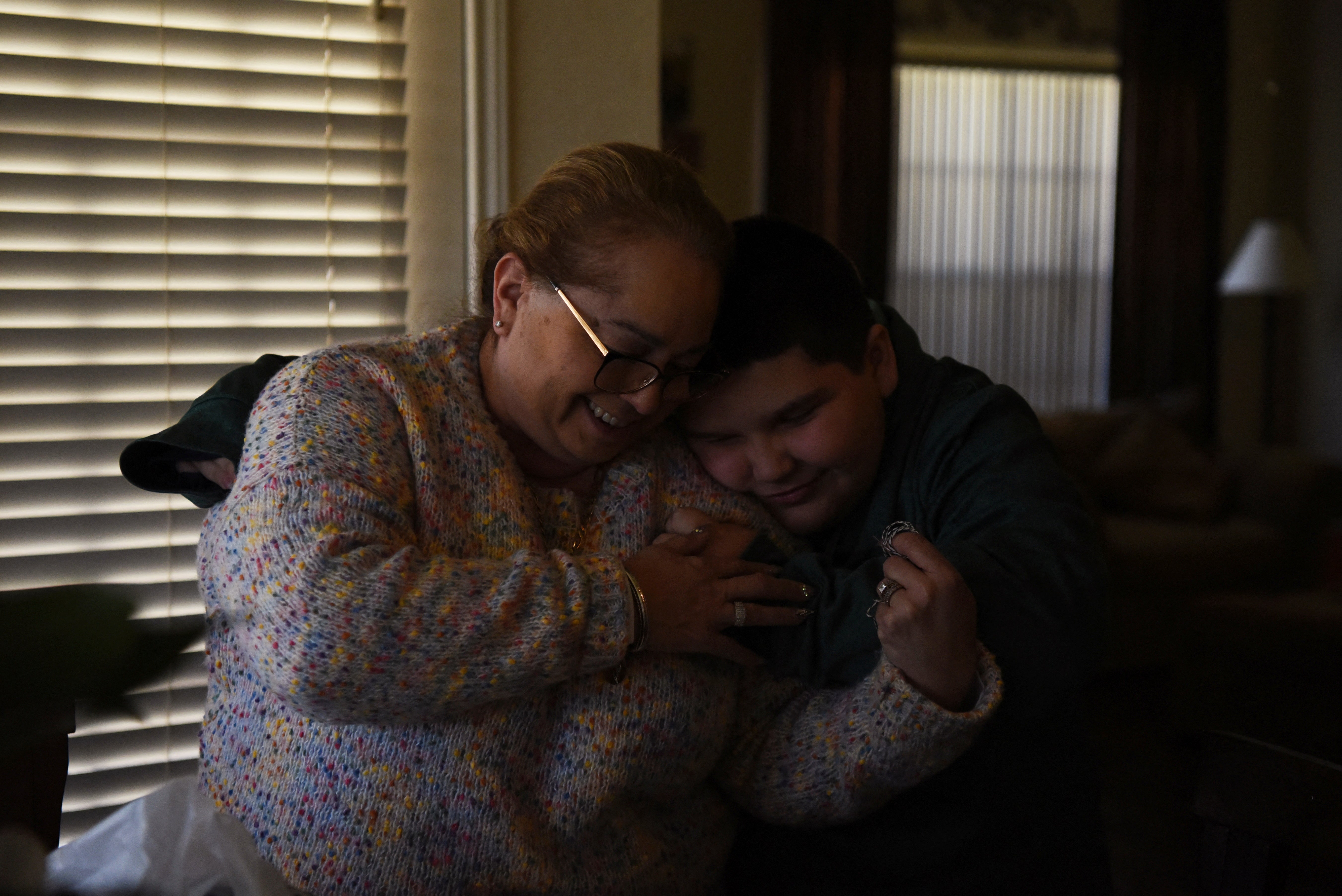 Aidan Garza shares a hug with his mother, Margaret Garza, at home in Converse, Texas