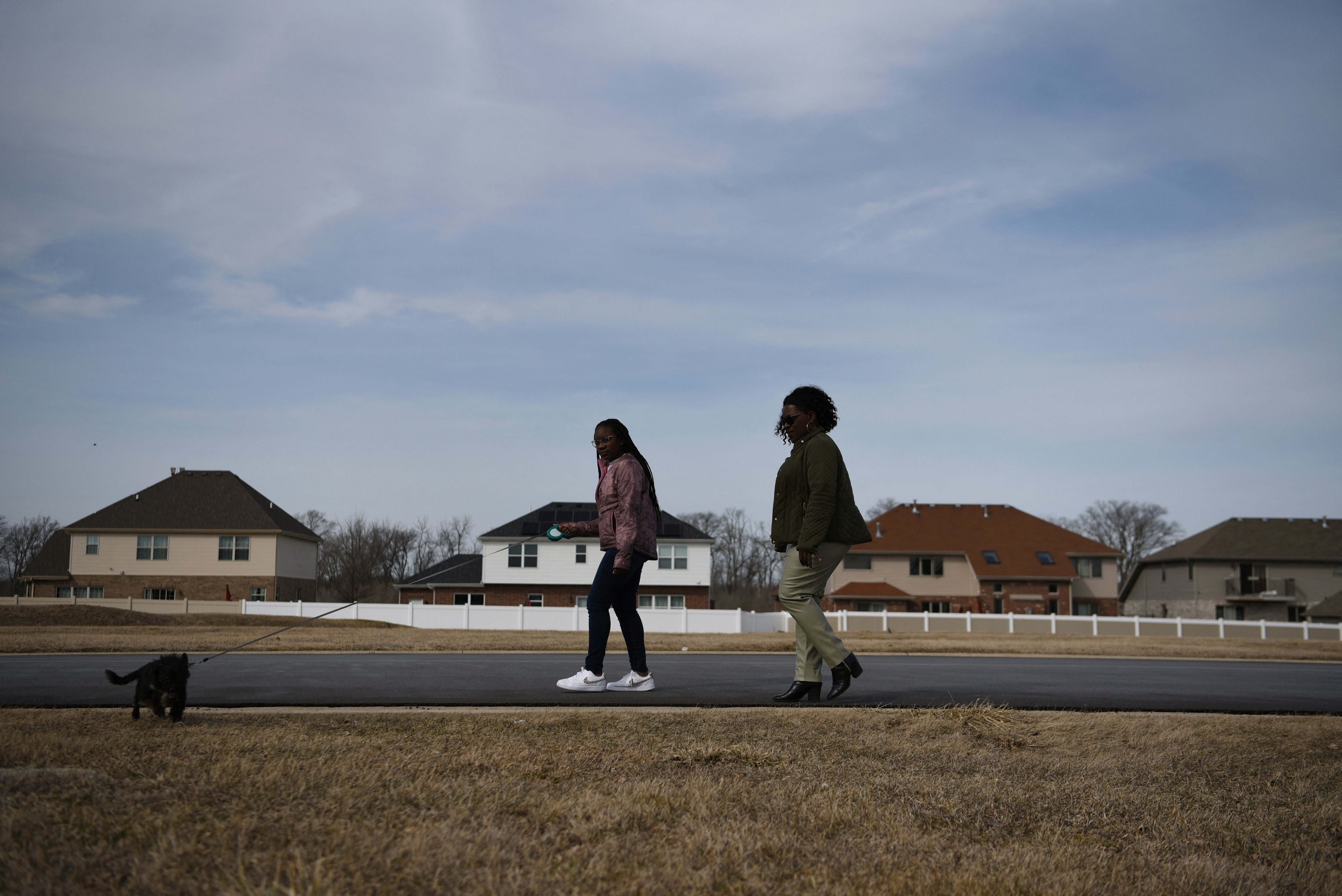 Dr. Sandra McGowan-Watts (L) and her daughter Justise McGowan (R) take the family dog for a walk around the neighbourhood