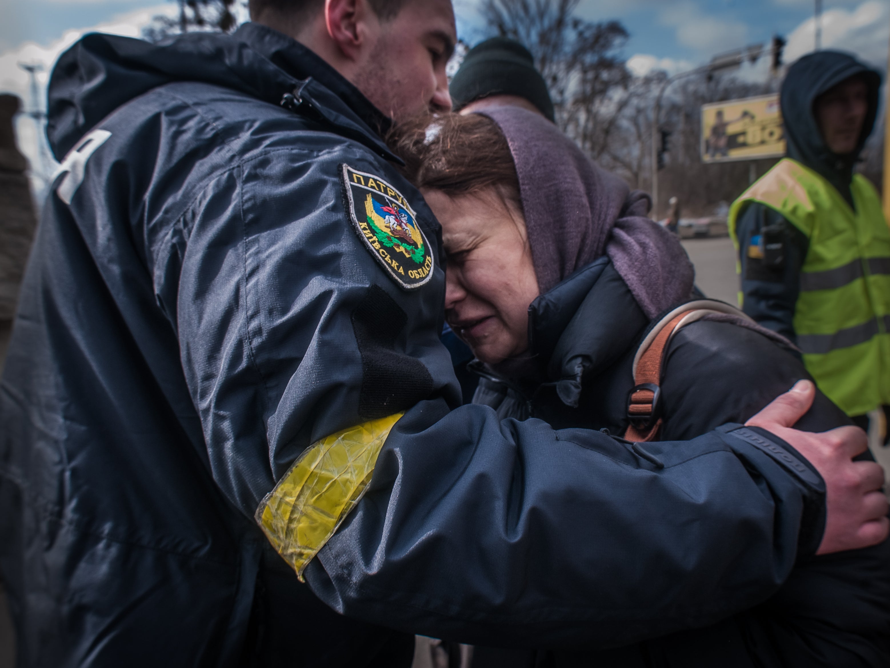 A woman from Irpin cries on a policeman’s shoulder as she is taken to an evacuation area of Kyiv