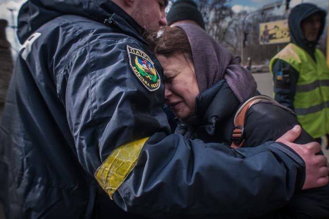 <p>A woman from Irpin cries on a policeman’s shoulder as she is taken to an evacuation area of Kyiv</p>