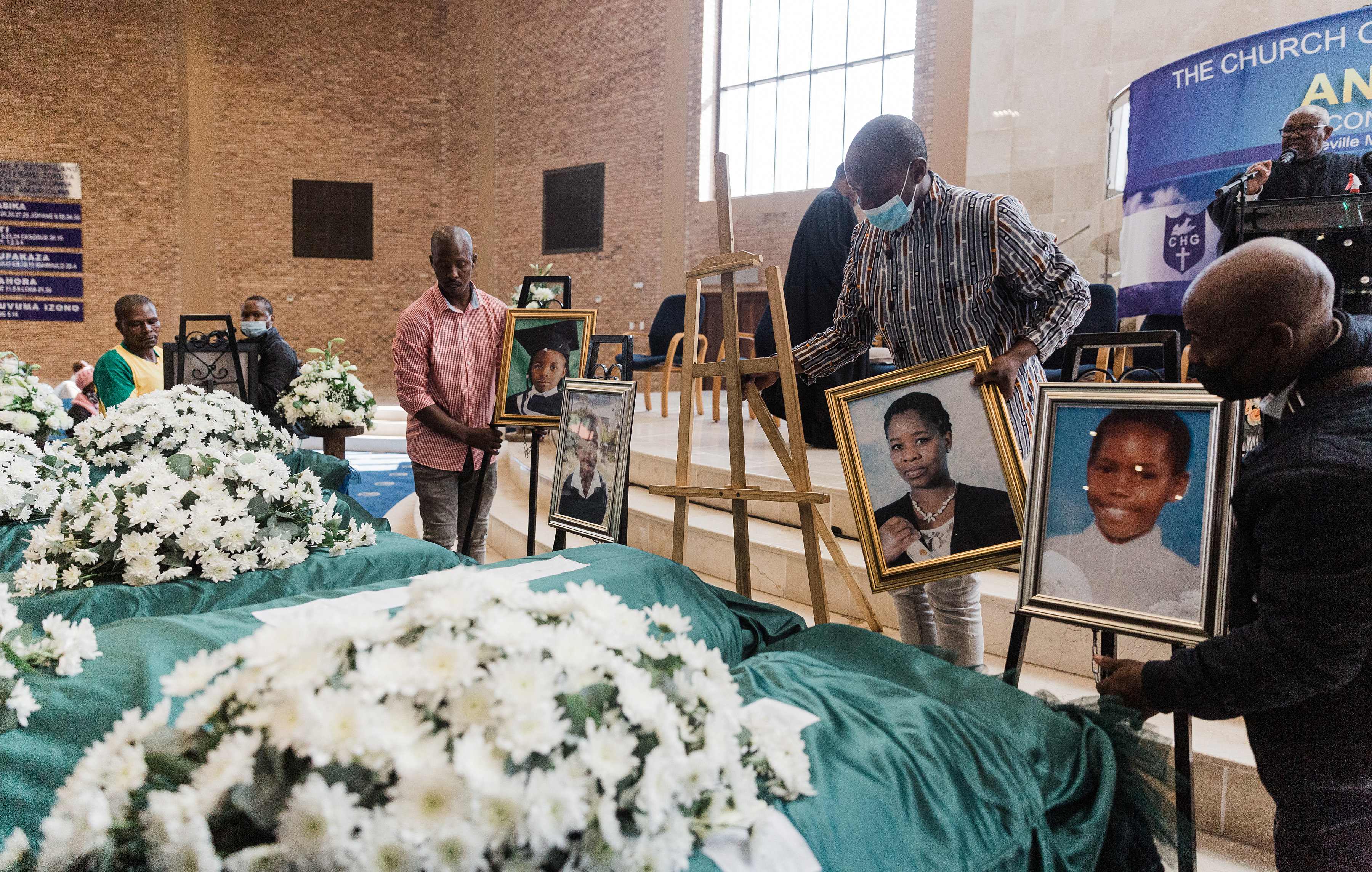 Photos are placed at the funeral service for the Jileka family, a single family who drowned when their home was engulfed in water following devastating floods in Kwa-Zulu Natal province