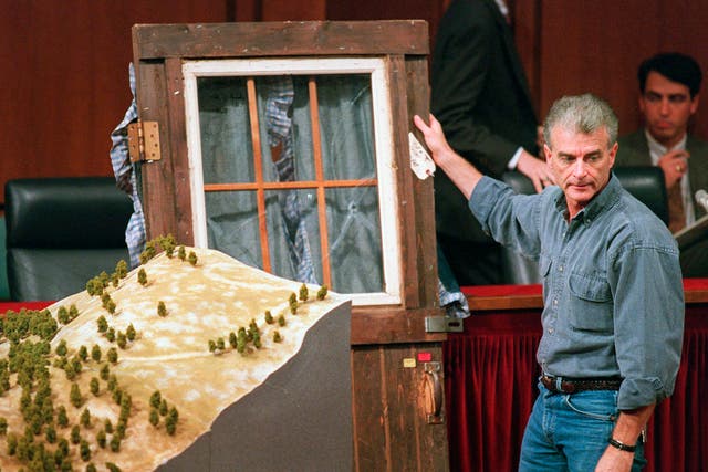 <p>Randy Weaver holds the bullet-ridden door of his cabin following the 1992 siege at Ruby Ridge</p>