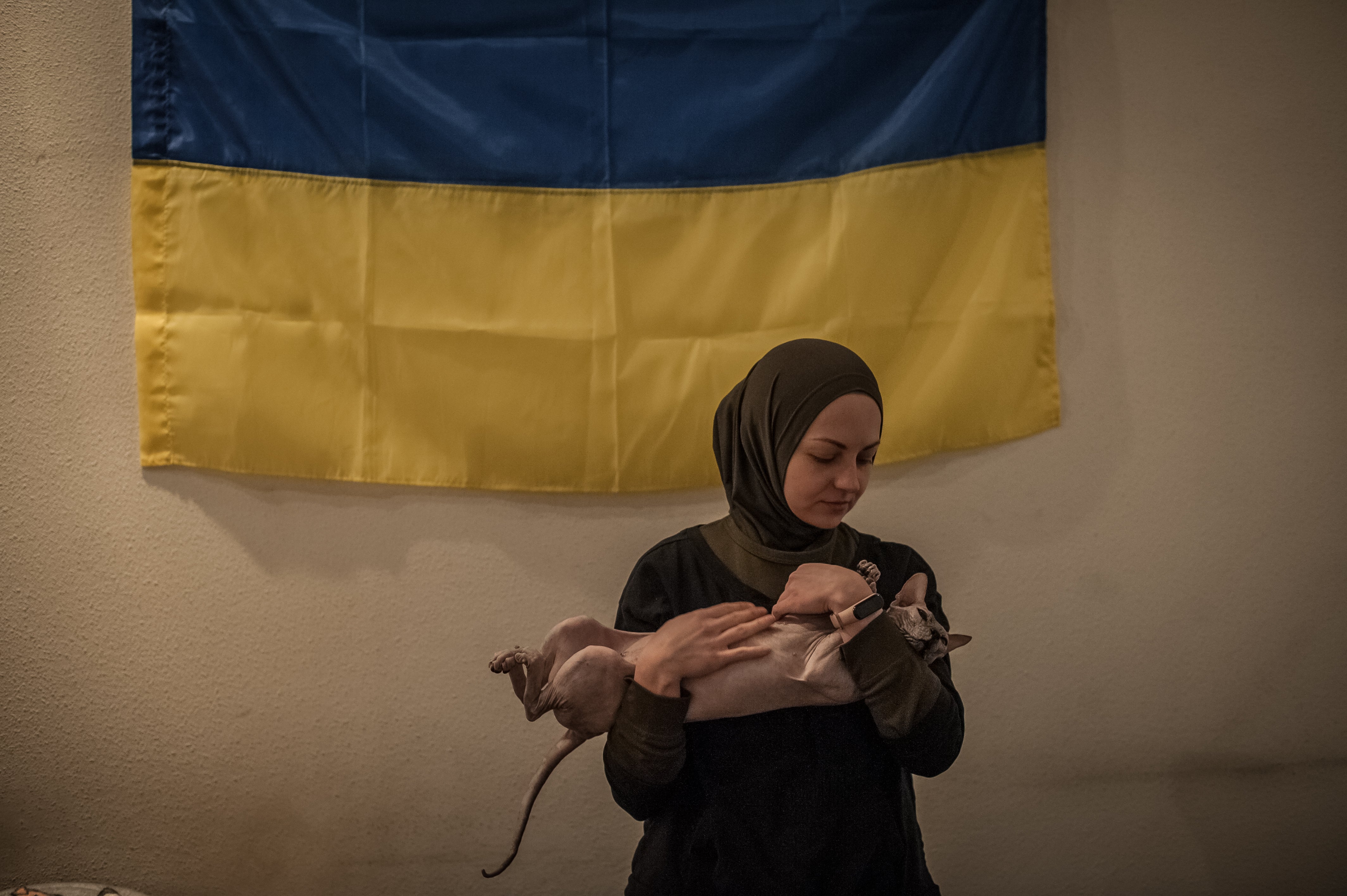 Viktoria with her cat in a volunteer centre where she and other volunteers help locals with food and the army with medical equipment