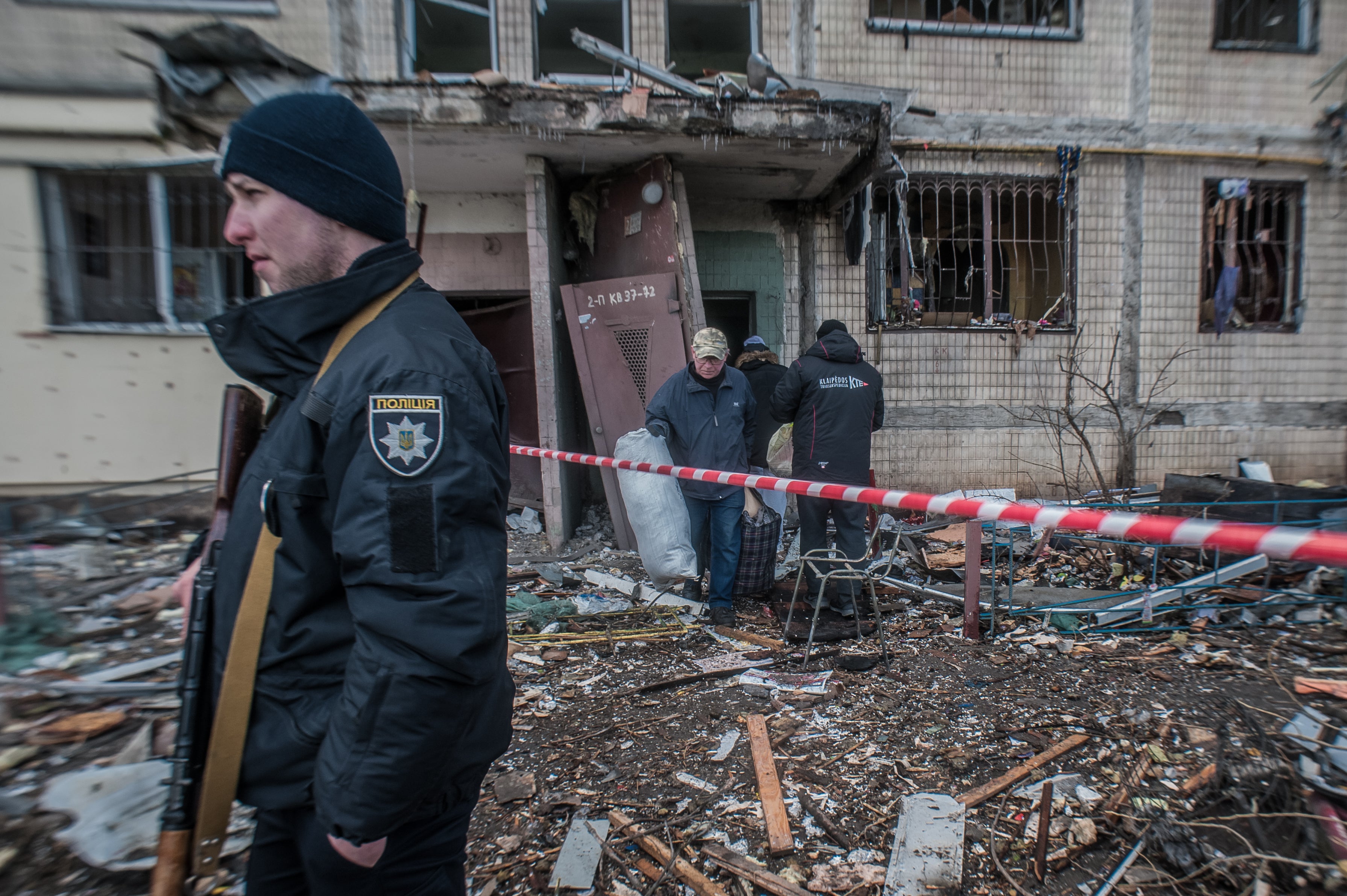 People try to save what is left of their belongings after a rocket hit their house on the outskirts of Kyiv