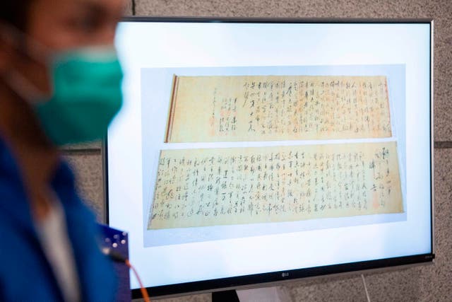 <p>Police show a picture of a calligraphy scroll written by Mao Zedong worth about 300 million USD, that had been recovered but found chopped in half at a press conference in Hong Kong</p>