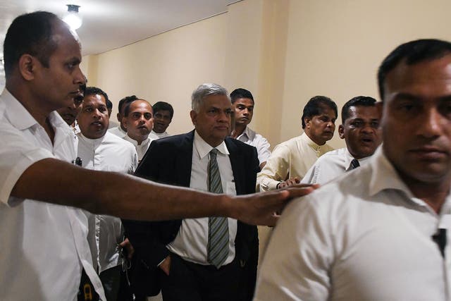 <p>Sri Lankan prime minister Ranil Wickremesinghe (Centre) leaves parliament escorted by security personnel and aides in Colombo </p>