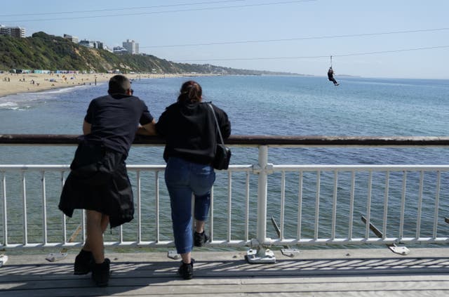 People watch from Bournemouth Pier in Dorset as a person zip wires to the beach (Andrew Matthews/PA)