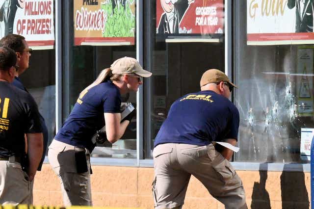 <p>FBI agents look at bullet impacts in a Tops Grocery store in Buffalo, New York, on May 15, 2022, the day after a gunman shot dead 10 people.</p>