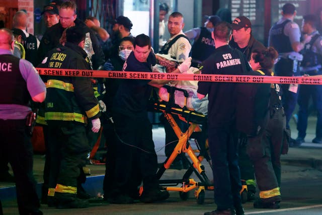 <p>First responders move a shooting victim to an ambulance on Adams Street near State Street in downtown Chicago on Saturday 14 May 2022</p>
