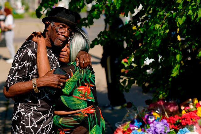<p>People embrace at the scene of the Buffalo supermarket shooting on Sunday, 15 May </p>
