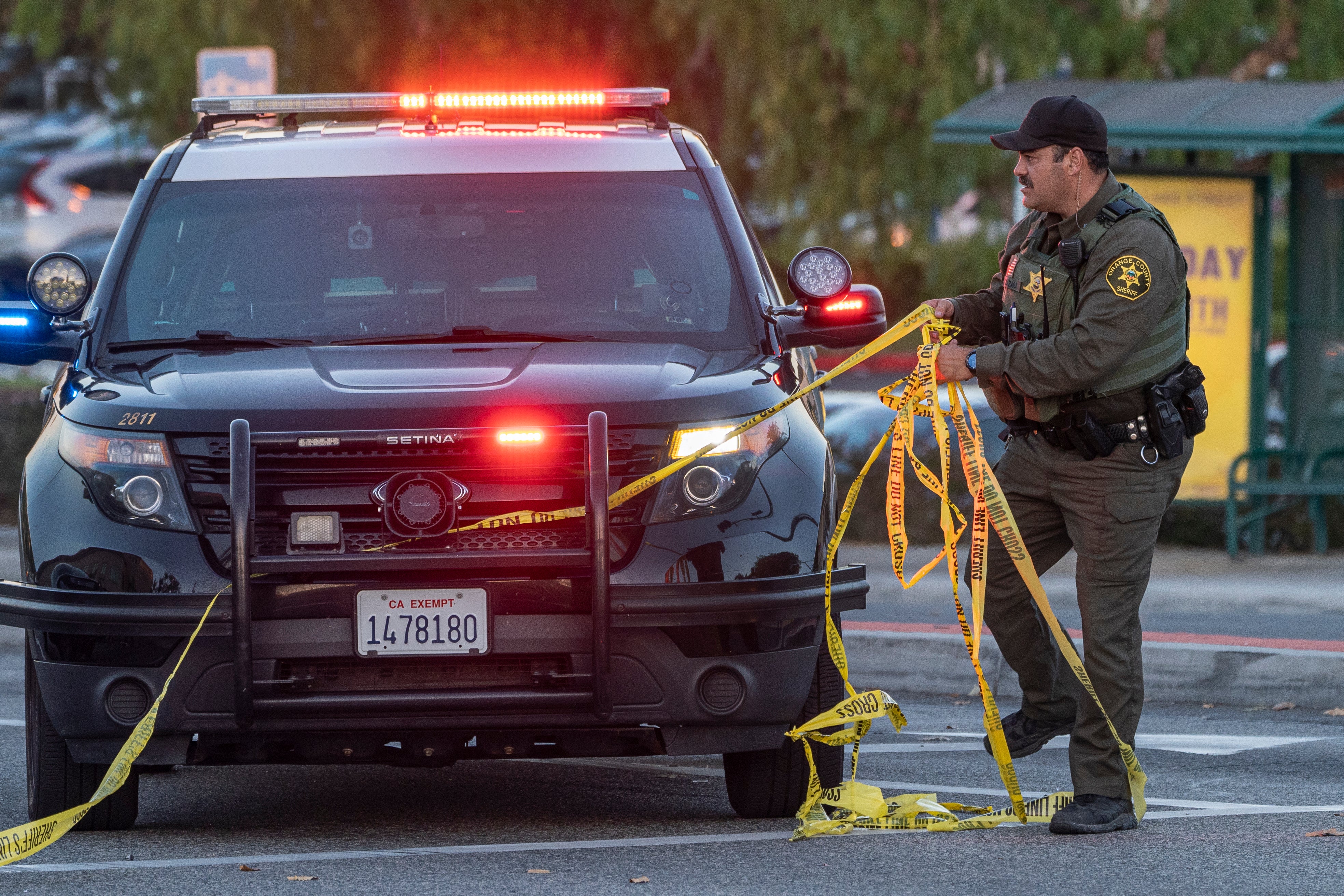 An Orange County sheriff deputy removes yellow tape from a vehicle outside the Geneva Presbyterian Church
