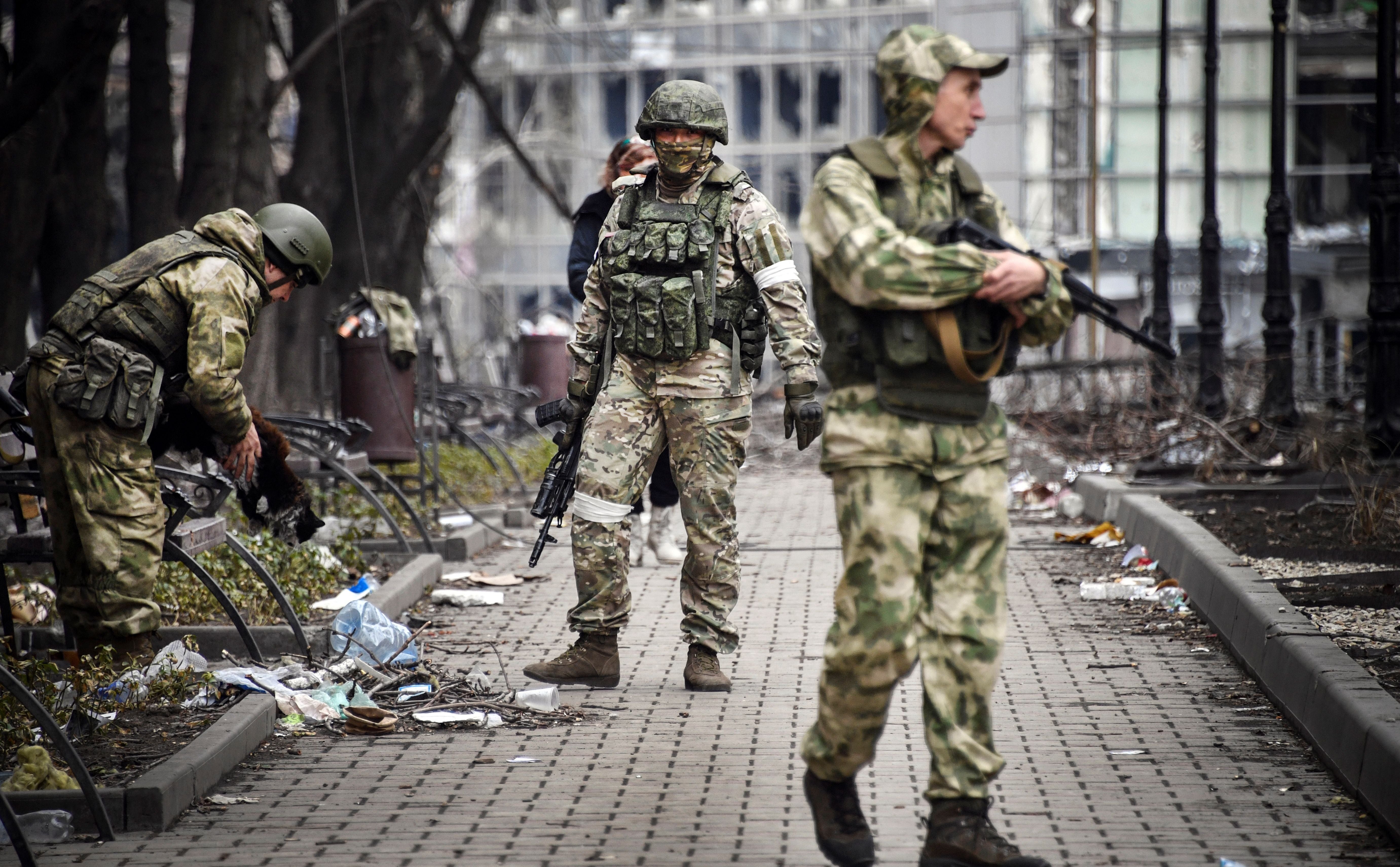 <p>Russian soldiers walk along a street in Mariupol on 12 April</p>