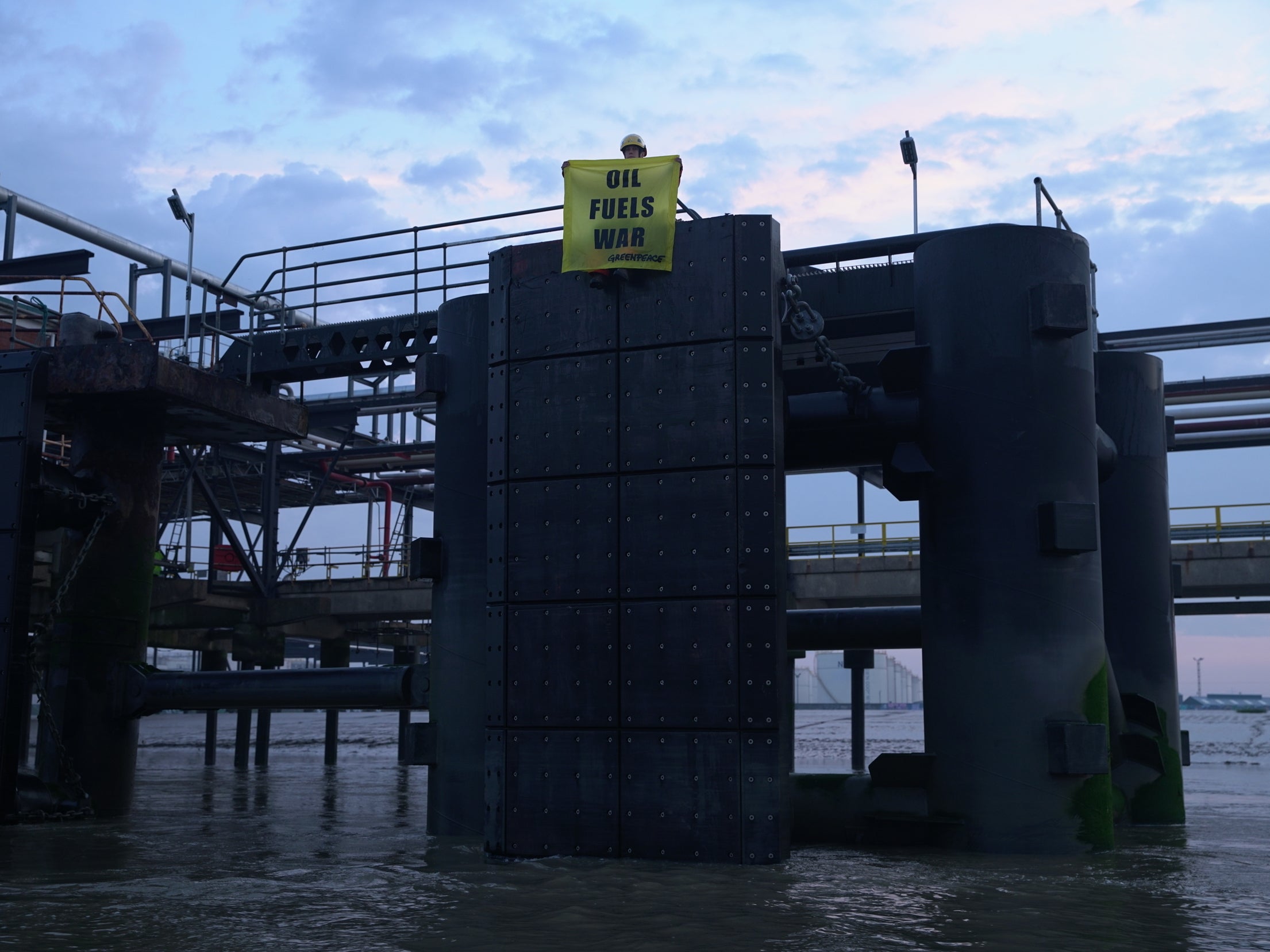 Greenpeace activists hold banner from docking site in Thames