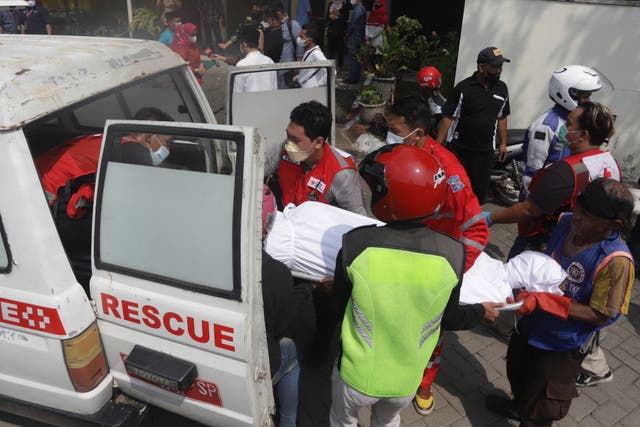 <p>Medical workers load a victim’s body into a vehicle after a bus crash in Mojokerto on 16 May 2022</p>