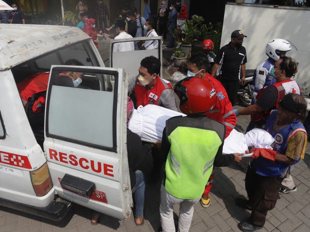 <p>Medical workers load a victim’s body into a vehicle after a bus crash in Mojokerto on 16 May 2022</p>