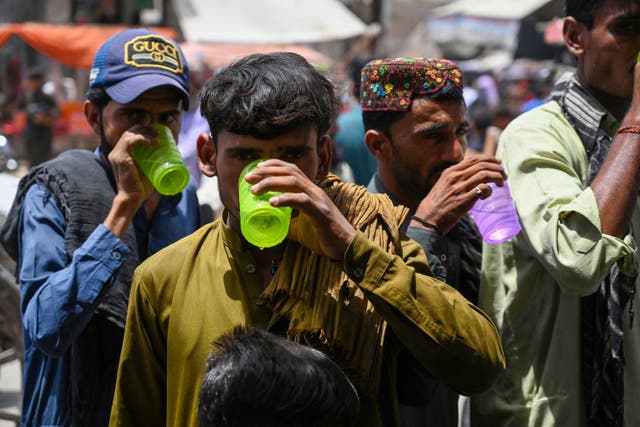 <p>People drink water distributed by volunteers in Jacobabad in Pakistan’s Sindh province</p>