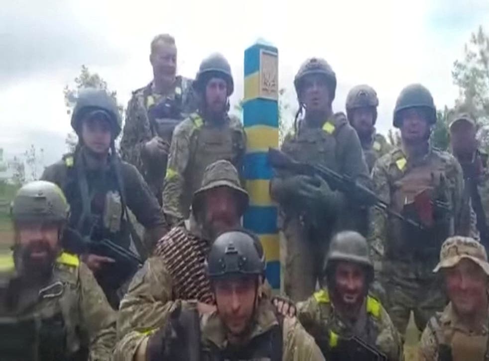 <p>A dozen Ukrainian troops stand beside what is said to be a border post near Kharkiv, Ukraine </p>
