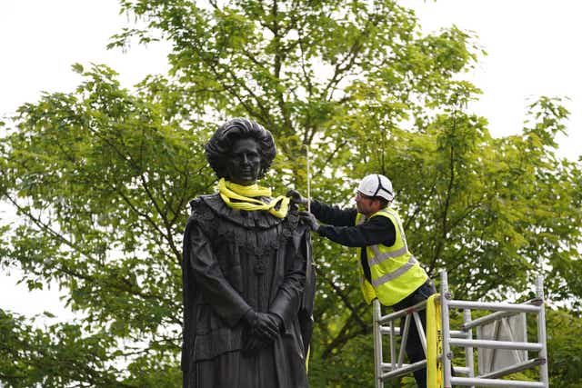 A worker removes the lifting straps from the newly installed statue of Baroness Thatcher in her home town of Grantham, Lincolnshire. Picture date: Sunday May 15, 2022.