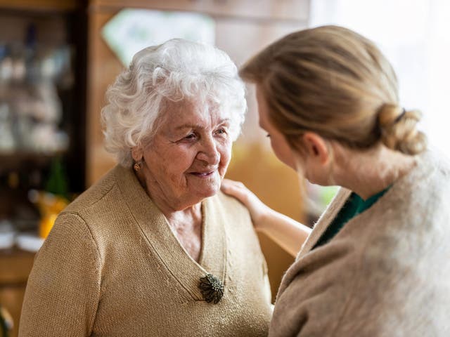 Un visitador de salud hablando con un anciano durante una visita a su hogar