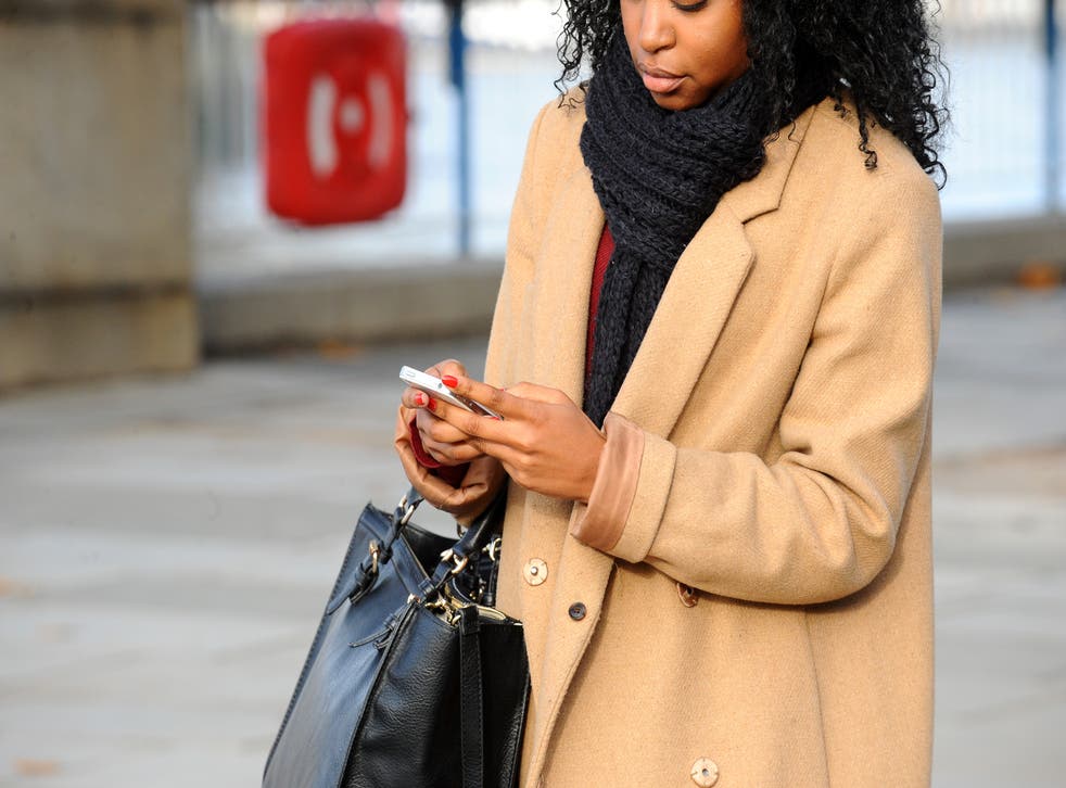 A generic stock photo of a woman using a mobile phone in central London.
