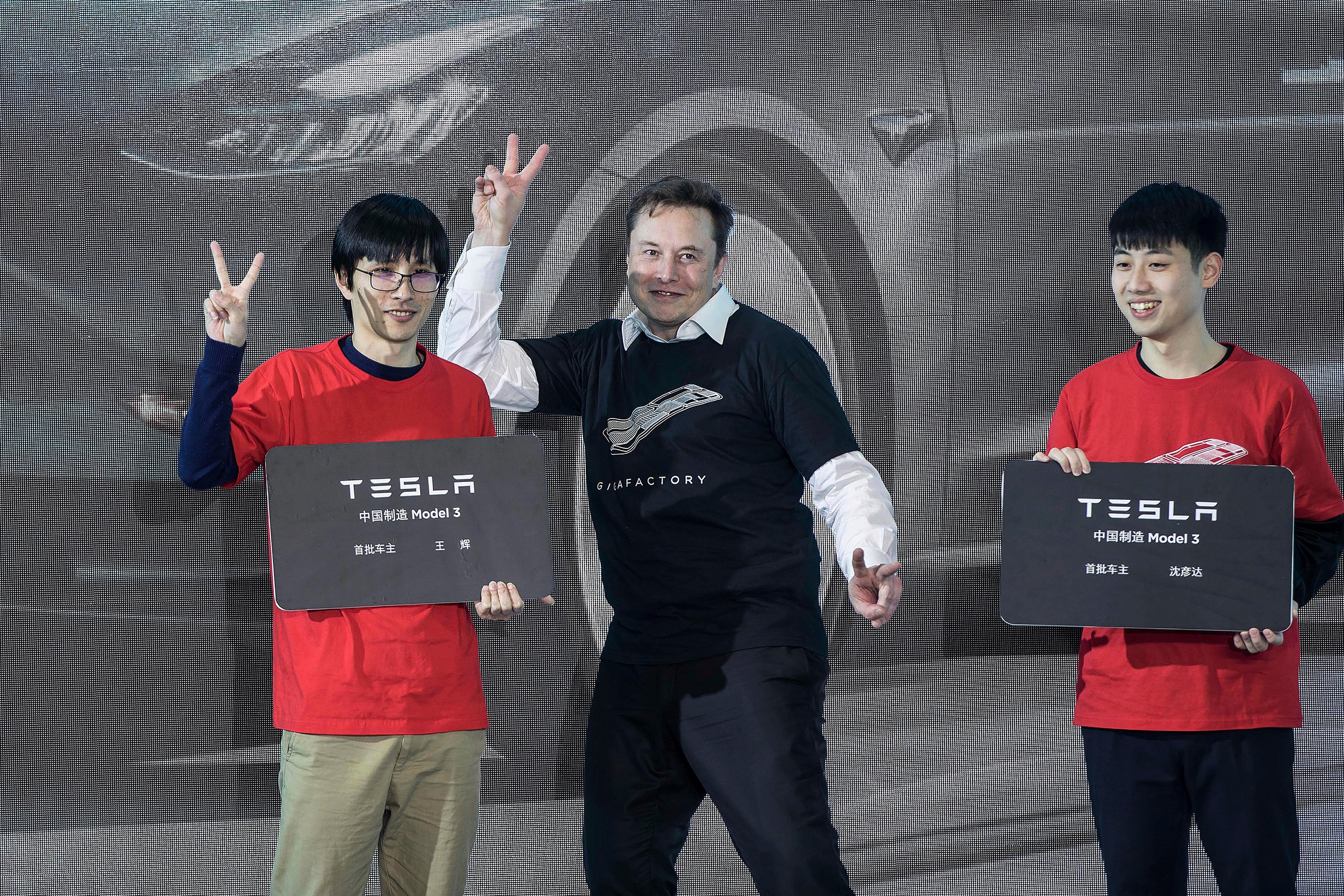 <p>Elon Musk poses with Tesla owners at a delivery ceremony for Model 3 cars in Shanghai, China, on 7 January 2020</p>