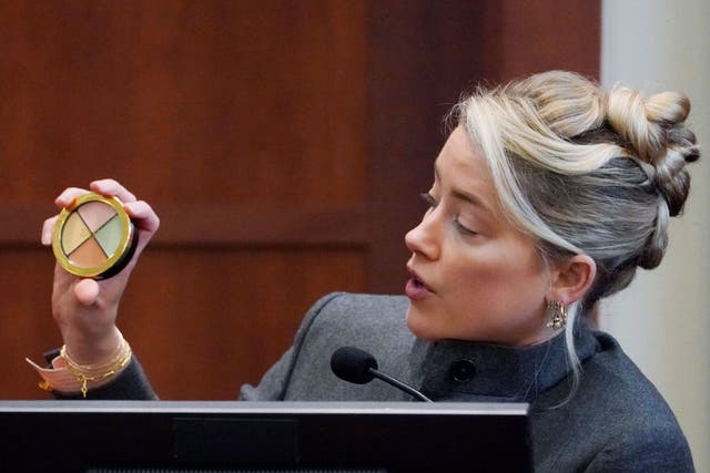 <p>Amber Heard testifies and displays a makeup kit in the courtroom at the Fairfax County Circuit Courthouse.</p>