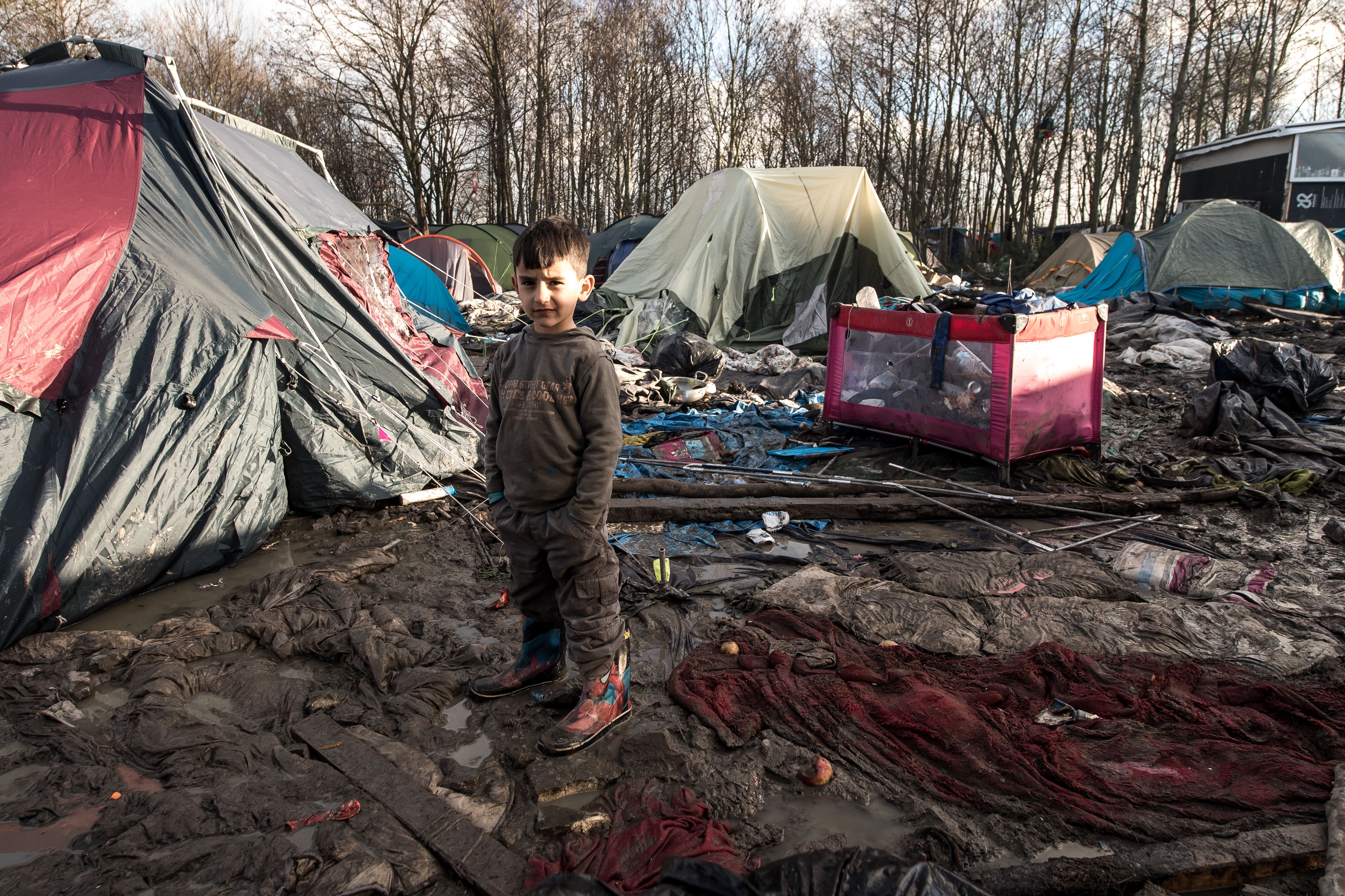 A boy poses in a migrant and refugee camp in Grande-Synthe near Dunkirk, northern France