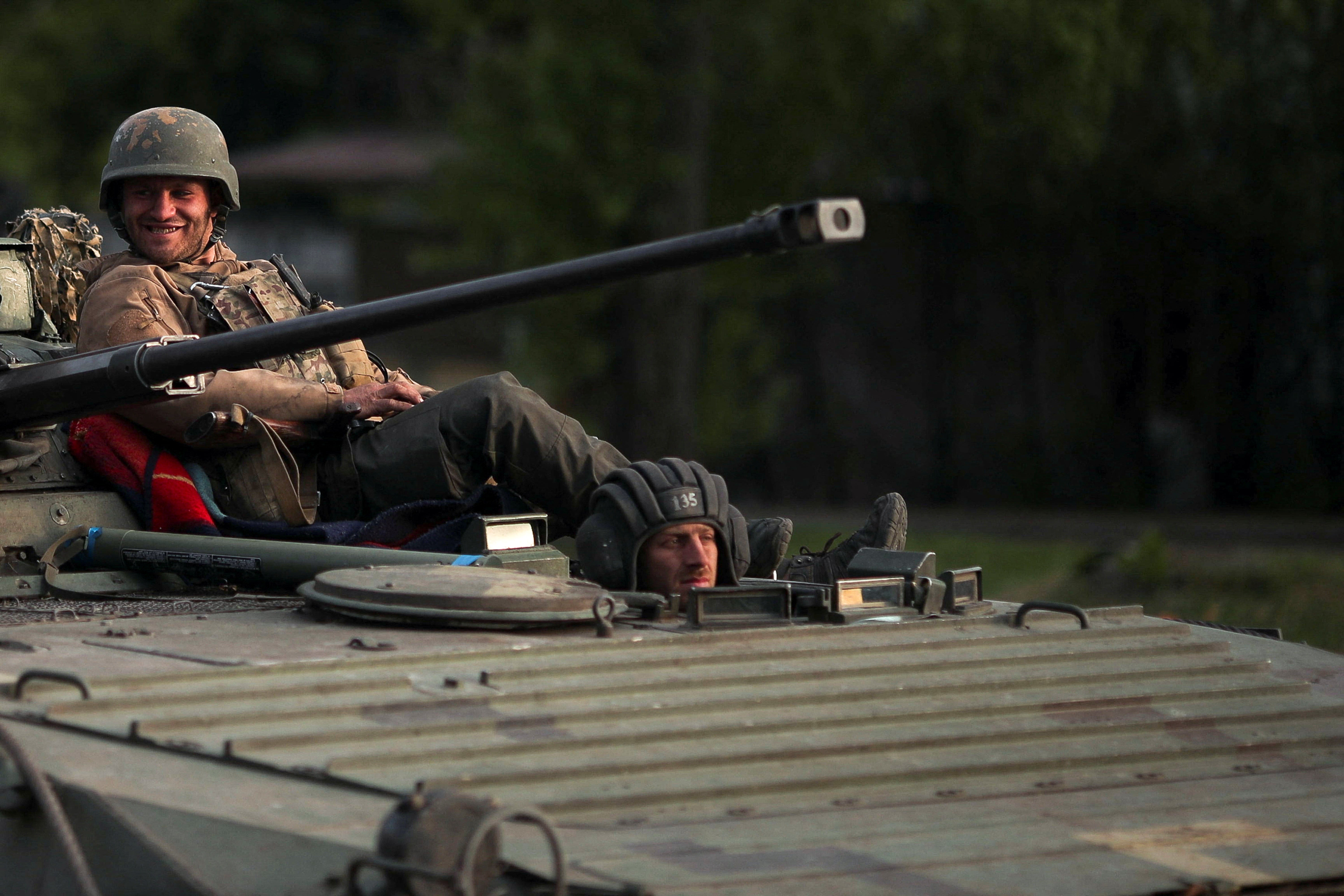 Ukrainian servicemen on top of an armoured vehicle in Kharkiv