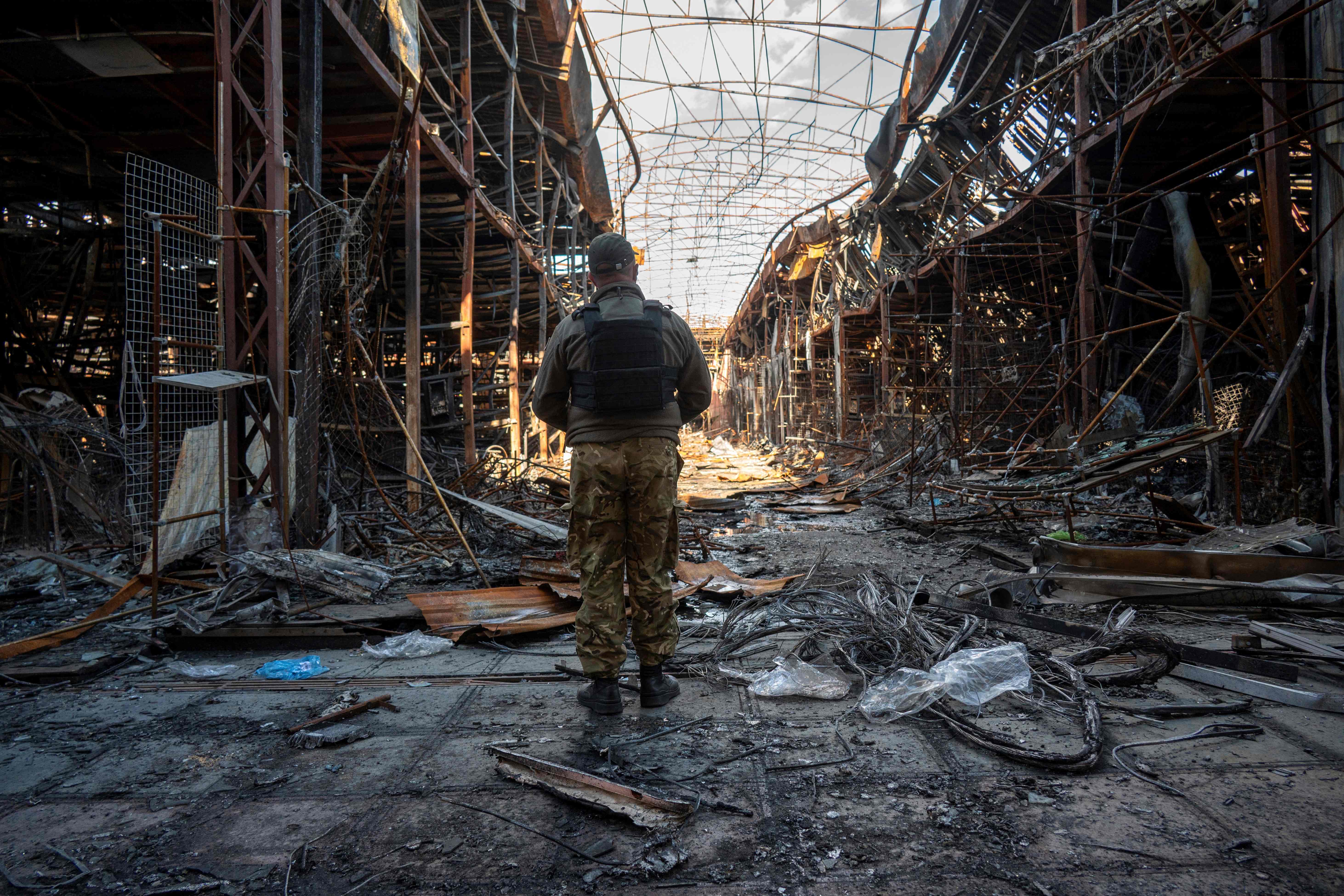 A Ukrainian police officer documents the destruction at the Barabashovo clothing market Kharkiv