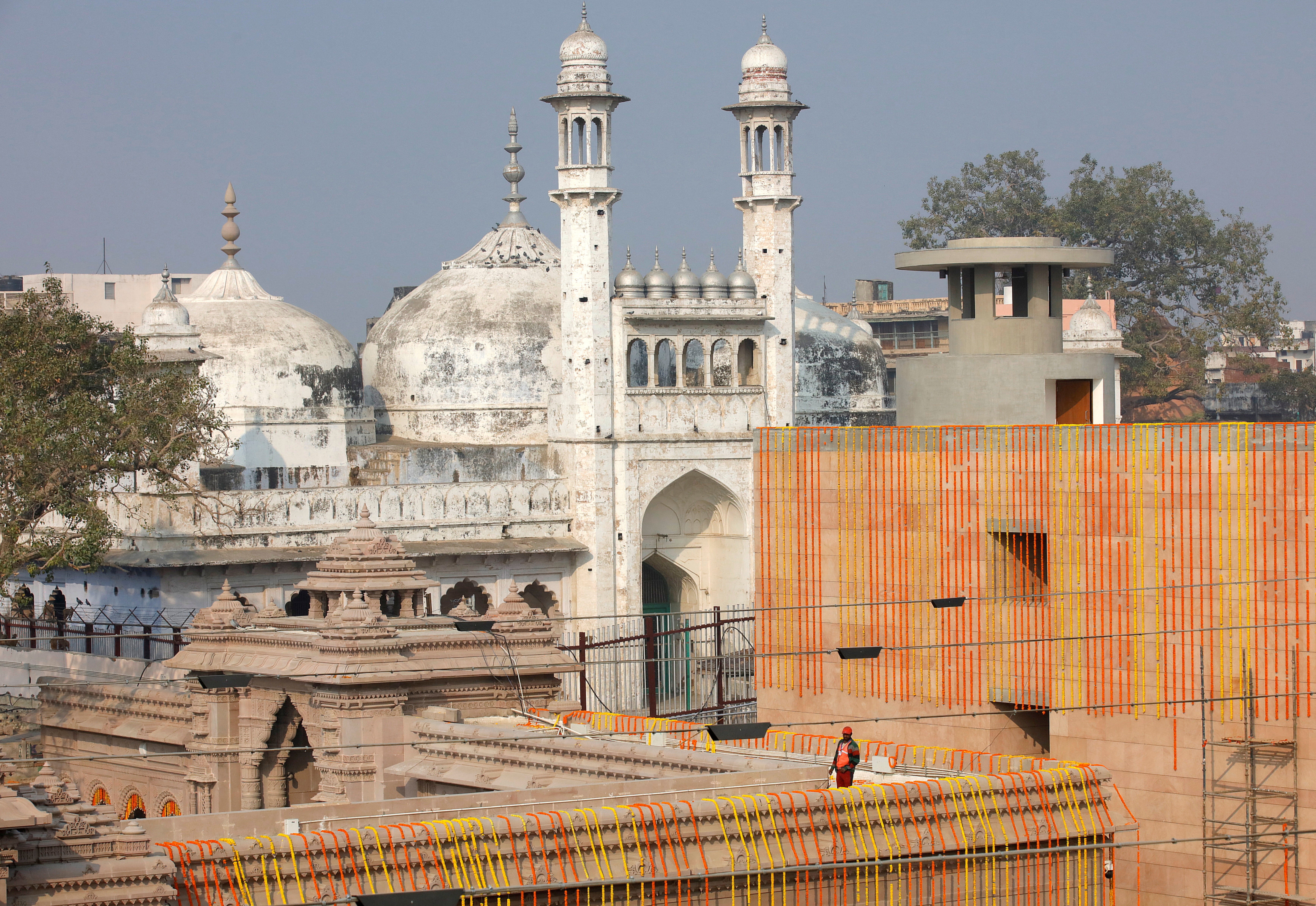 File photo: A worker stands on a temple rooftop adjacent to the Gyanvapi Mosque in the northern city of Varanasi