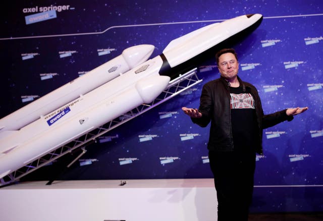 <p>SpaceX owner and Tesla CEO Elon Musk stands in front of a model rocket</p>