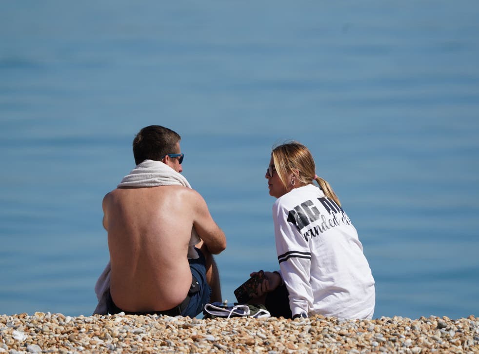 <p>A man and woman enjoying the warm weather on a beach near Dover </p>