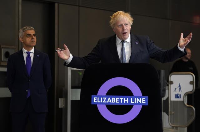 <p>Mayor of London Sadiq Khan looks on as Boris Johnson speaks at the completion of the Elizabeth line in 2022 (Andrew Matthews/PA)</p>